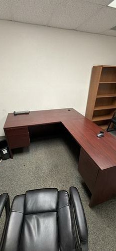 L-shaped office desk — reddish wood-look finish